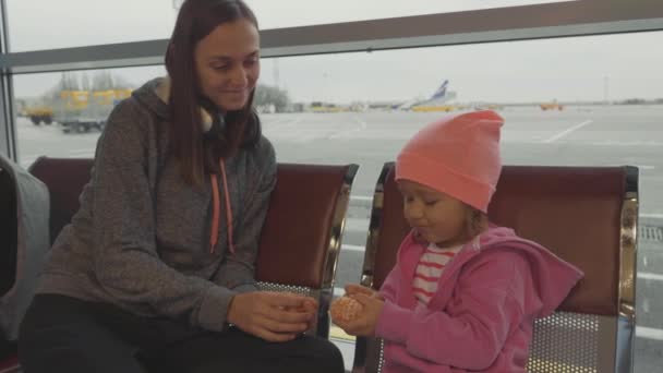 Anne ve kızı Havaalanı'nda. Küçük kız mandarin bekleyen Hall. — Stok video