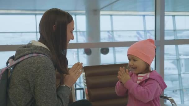 Yound anne ve küçük şirin kız ağır çekimde havaalanında eğleniyor. — Stok video
