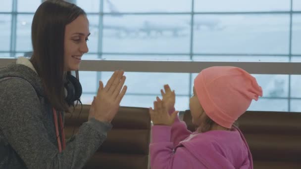Yound moeder en schattig dochtertje plezier op de luchthaven in slow motion. — Stockvideo