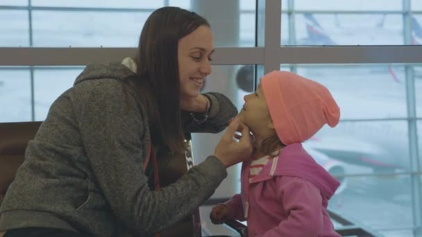 Yound mor och lilla söta dotter ha kul på flygplats i slow motion. — Stockvideo