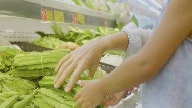 Küçük kızı yeşil sebzeler markette seçimi ile genç anne
