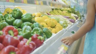 Küçük kız bakkal, dikiz sebzeli raflar geçmiş yürüyüş