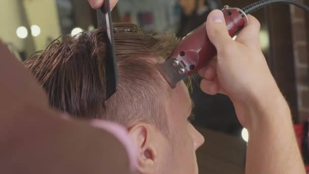 Peluquero macho hace corte de pelo con afeitadora eléctrica, en cámara lenta . — Vídeos de Stock