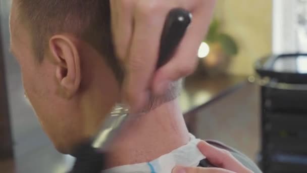 Fryzjer wykończenia fryzury i oczyszcza szyi klienta przez pędzla. — Wideo stockowe