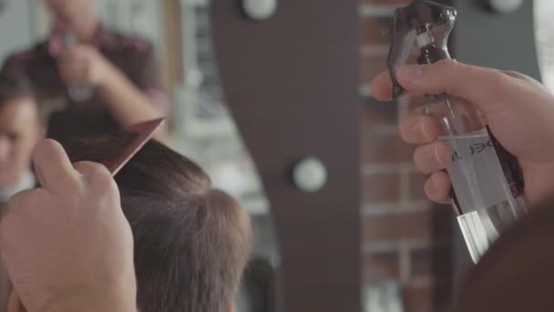 Nahaufnahme des Friseurs spritzt vor dem Haarschnitt in Zeitlupe Wasser auf die Haare des Kunden — Stockvideo