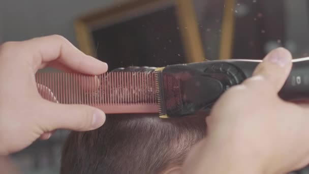 Peluquero macho hace corte de pelo con afeitadora eléctrica, en cámara lenta . — Vídeos de Stock