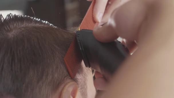 Мужчина парикмахер делает стрижку с электрической бритвой, в замедленной съемке . — стоковое видео