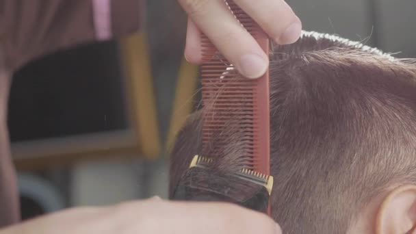 Peluquero macho hace corte de pelo con afeitadora eléctrica, en cámara lenta . — Vídeos de Stock