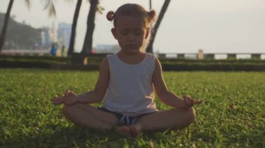 Gün batımında parkta Türk poz küçük şirin kız meditasyon.