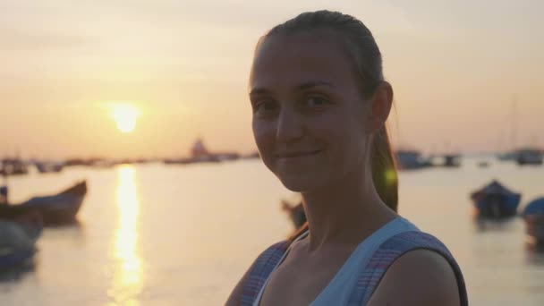 슬로우 모션으로 해변에서 카메라에 보이는 행복 한 젊은 여자의 초상화. — 비디오