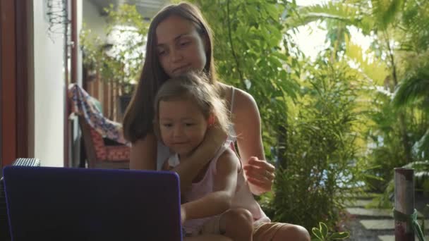 Jonge vrouw met een schattig dochtertje met laptop samen in slow motion — Stockvideo