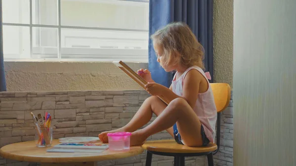 Детская девочка рисует акварелью дома . — стоковое фото