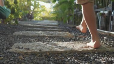 Küçük kız bahçede yolda yürürken. Yakın çekim ayak uzakta kameradan git.