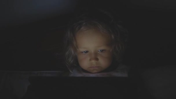 小女孩的肖像在晚上在家床上使用平板电脑技术. — 图库视频影像