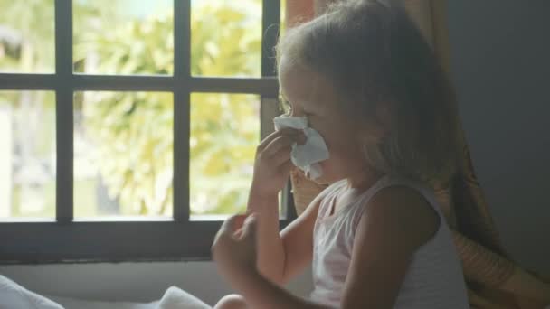 Närbild av liten flicka blåser och torka näsan med en sanitära servett — Stockvideo