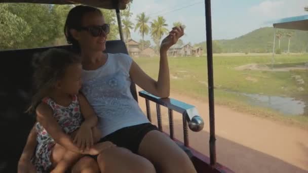 Туристична сім'я, мати і дочка катаються на традиційних перевезеннях тукуку — стокове відео