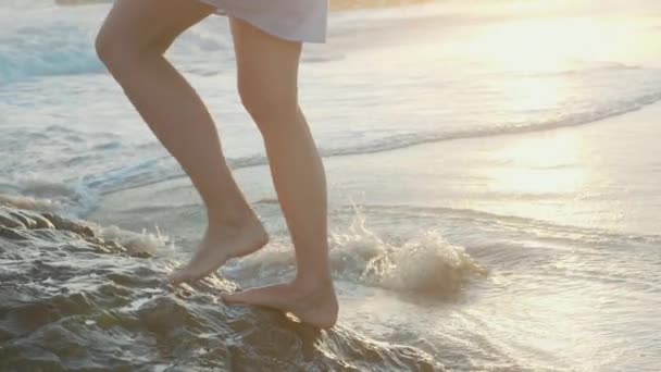 Nackte Frauenfüße am felsigen Strand. Beine am Stein vorbei am Ufer. — Stockvideo