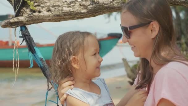 Mutter hat Spaß mit ihrer kleinen süßen Tochter auf Hängematte am Sandstrand — Stockvideo