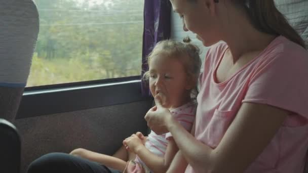 Giovane madre che nutre la figlioletta nell'autobus, al rallentatore . — Video Stock