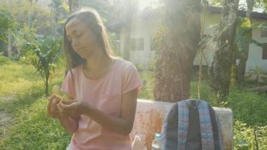 Bank Asya kırsal Köyü'nde oturan ve muz yemek genç kadın