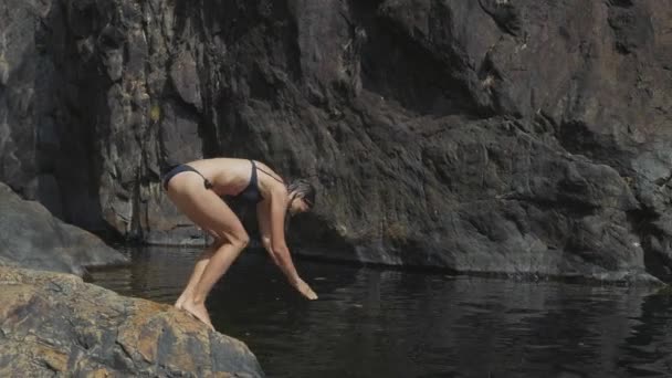 Jovem mulher mergulha na água do lago da montanha em câmera lenta — Vídeo de Stock