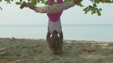 Yoga exersice hamak Beach ile yapıyor küçük şirin çocuk kız.