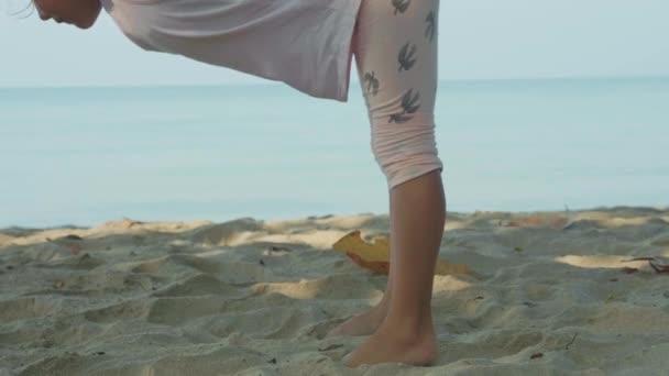 Piccola bambina carina che fa esercizi di yoga con amaca in spiaggia . — Video Stock