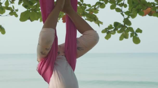 Piccola bambina carina che fa esercizi di yoga con amaca in spiaggia . — Video Stock