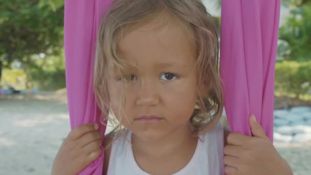 Piccola bambina carina che fa esercizi di yoga con amaca sulla spiaggia . — Video Stock