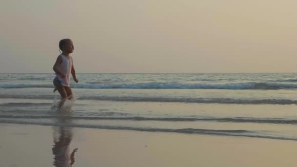 Ağır çekimde deniz kıyısında eğleniyor bebek ile anne. — Stok video