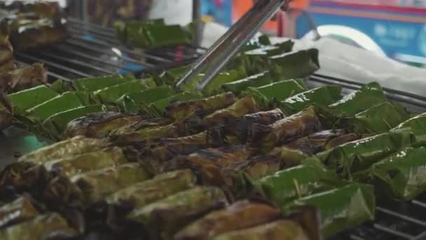 Zoete kleefrijst met banaan gebak vallende bananenblad gegrild op de barbecue. — Stockvideo