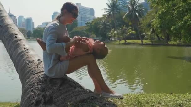 Семья развлекается в парке на фоне озера и небоскребов — стоковое видео