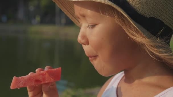 Retrato de hermosa linda niña comiendo sandía con placer, primer plano — Vídeo de stock