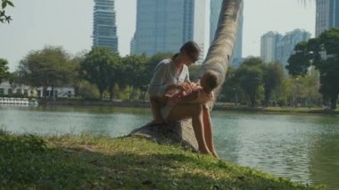 Aile göl ve arka planda gökdelenler ile parkta eğleniyor