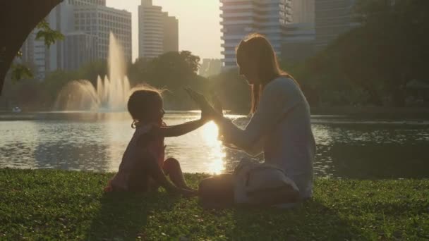 湖と背景の高層ビルと公園で楽しい家族 — ストック動画