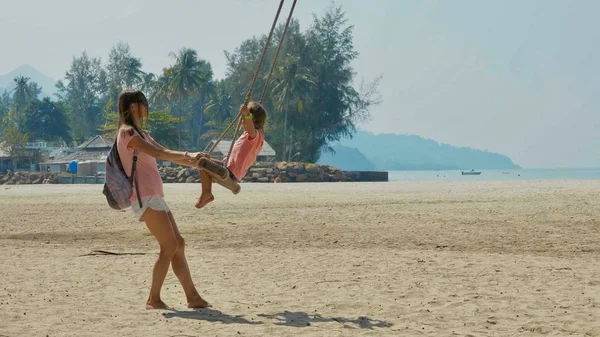 Menina rindo feliz balançando na praia de areia tropical — Fotografia de Stock
