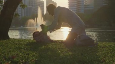 Aile göl ve arka planda gökdelenler ile parkta eğleniyor