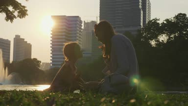 Aile göl ve arka planda gökdelenler ile parkta eğleniyor