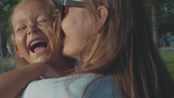Portret van lachen kind meisje in haar moeders hugs buiten — Stockvideo