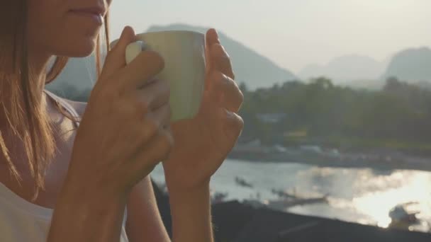 Mujer joven bebiendo café caliente en el balcón con hermoso paisaje de montaña — Vídeos de Stock