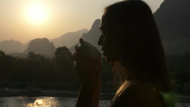 Νεαρή γυναίκα πίνει ζεστό καφέ στο μπαλκόνι με όμορφο ορεινό τοπίο — Αρχείο Βίντεο