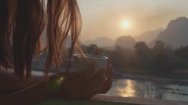Jonge vrouw drinken hete koffie op het balkon met prachtige berglandschap — Stockvideo