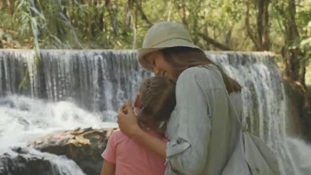 Młoda matka i jej córka odpoczynku kaskady wodospadu — Wideo stockowe