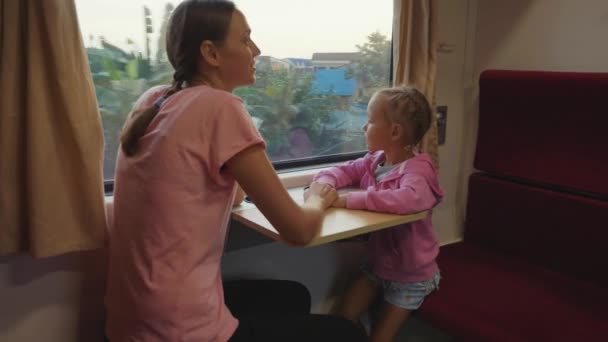 Família passando o tempo na viagem de trem na Ásia, olhando para a janela e conversando — Vídeo de Stock