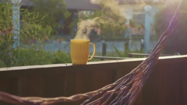 Steaming hot cup of tea on the terrace with no people in slow motion — Stock Video