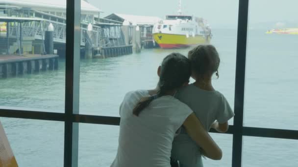 Ung mamma och lilla dotter väntar en resa på seaport lounge. — Stockvideo