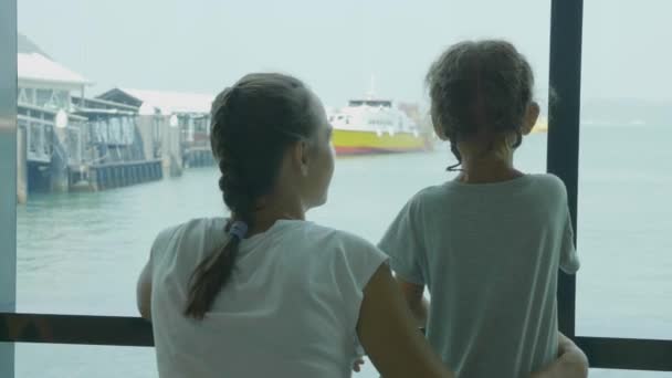 年轻的母亲和小女儿在海港休息室等待航程. — 图库视频影像