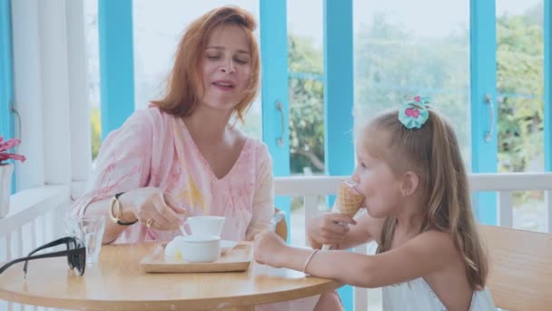 Jonge moeder en haar dochtertje tijd doorbrengen in een café met ijs — Stockvideo