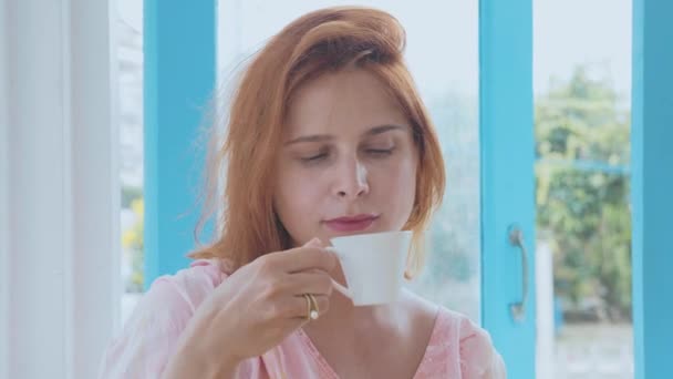 Portret van jonge mooie vrouw, drinken koffie in slow motion — Stockvideo