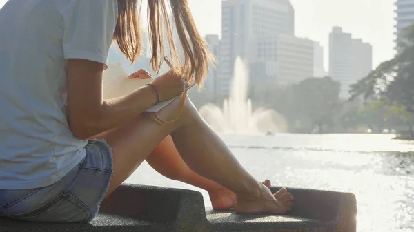 Tezgah Parkı ve günlüğünde, yazma oturan genç kadın yakın çekim
